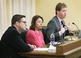 Jim Pearson and Mona Meyer sit at the testifiers' table and look at someone out of view. Representative Stephenson sits next to them and speaks to someone out of view.
